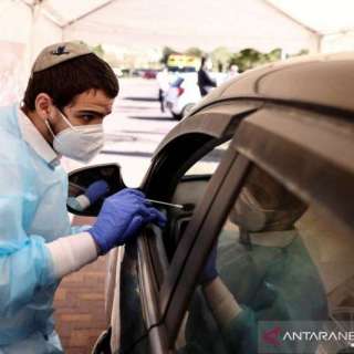 A health worker administers a swab test at a drive-thru testing center in Jerusalem.